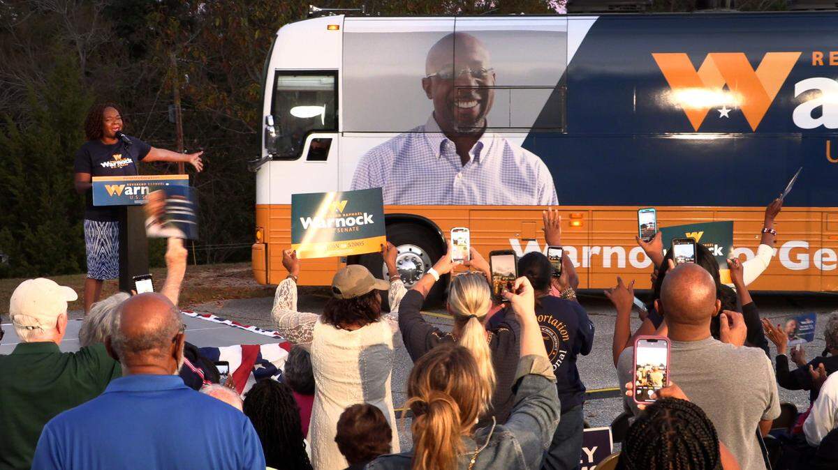 U.S. Sen. Raphael Warnock campaigns Monday night at Abundant Life Full Gospel Outreach Church in Columbus.