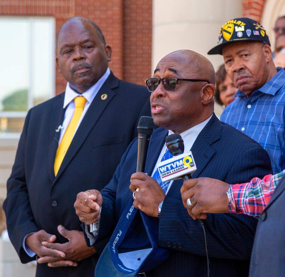 The Rev. J. H. Flakes III, center, senior pastor at Fourth Street Missionary Baptist Church in Columbus, speaks during a Wednesday afternoon news conference at the City Services Center in Columbus.