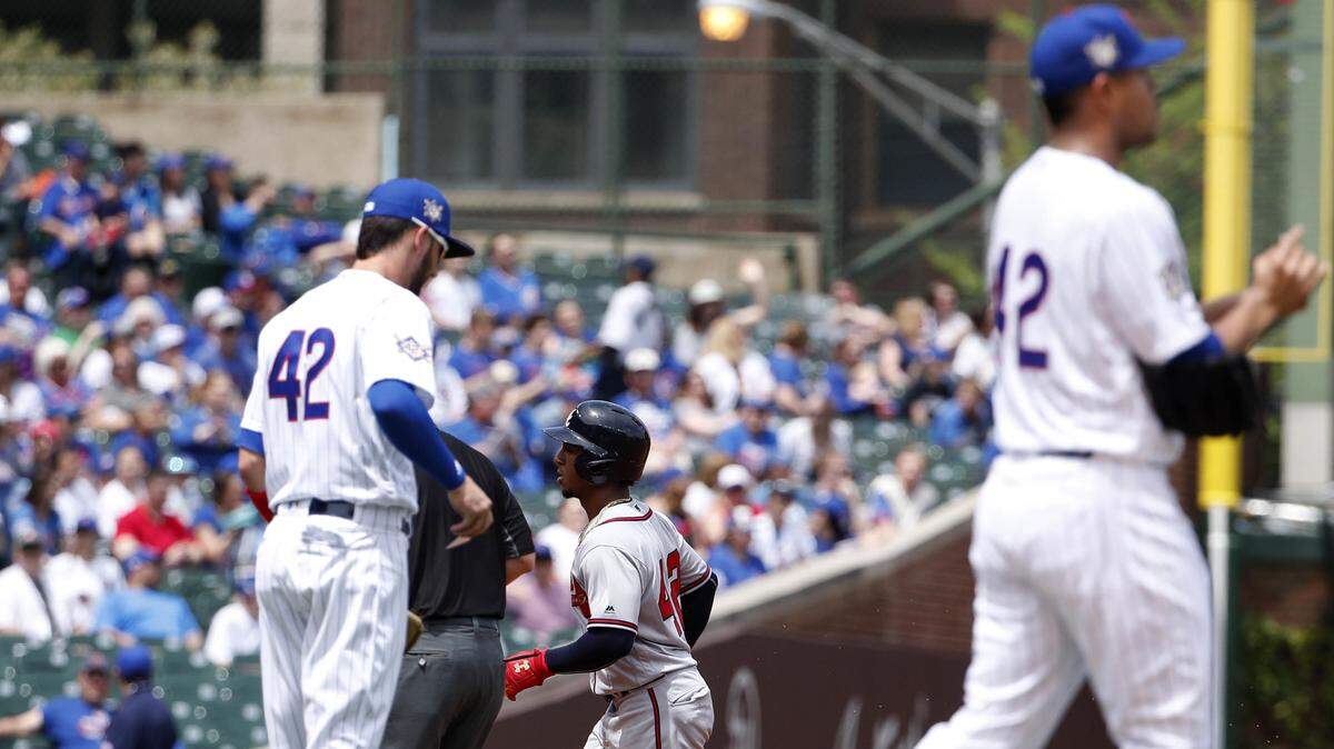 Atlanta Braves' Ozzie Albies, center, rounds the bases after hitting a solo home run off Chicago Cubs' Jose Quintana, right, during the first inning of a baseball game, Monday, May 14, 2018, in Chicago