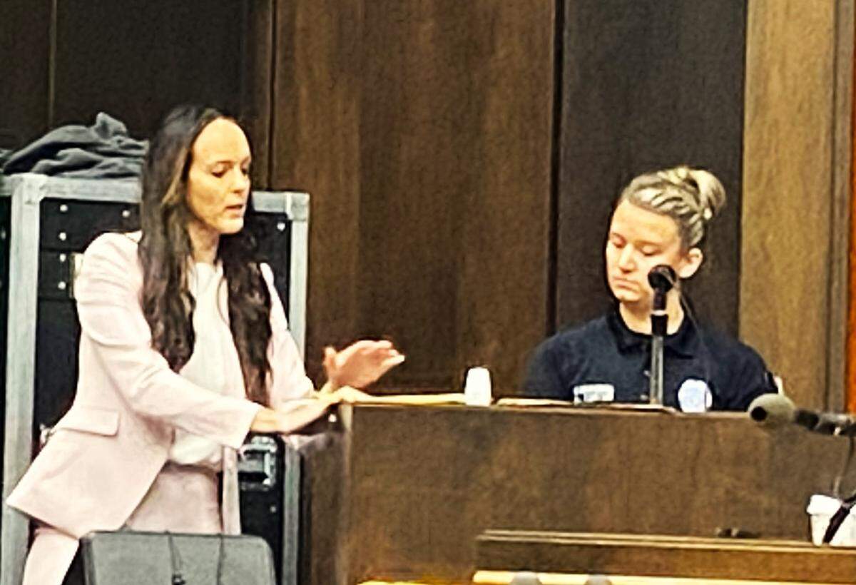 Prosecutor T. McKenzie Gray shows police Cpl. Leann Cortes crime-scene photos during Cortes’ testimony in an alleged gang slaying.