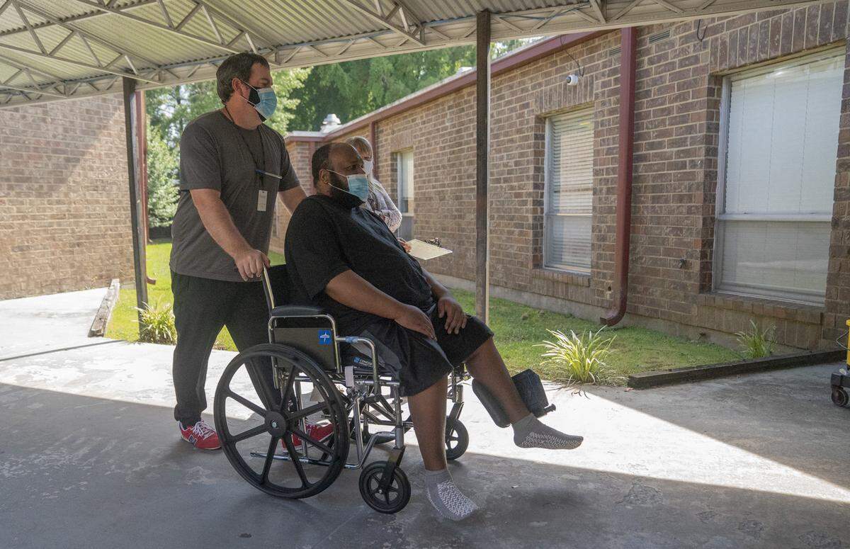 Physical therapist assistant Brian Wilkinson takes Eric Lofton back to his room after physical therapy on May 26, 2021, at River Towne Center nursing facility in Columbus, Ga.