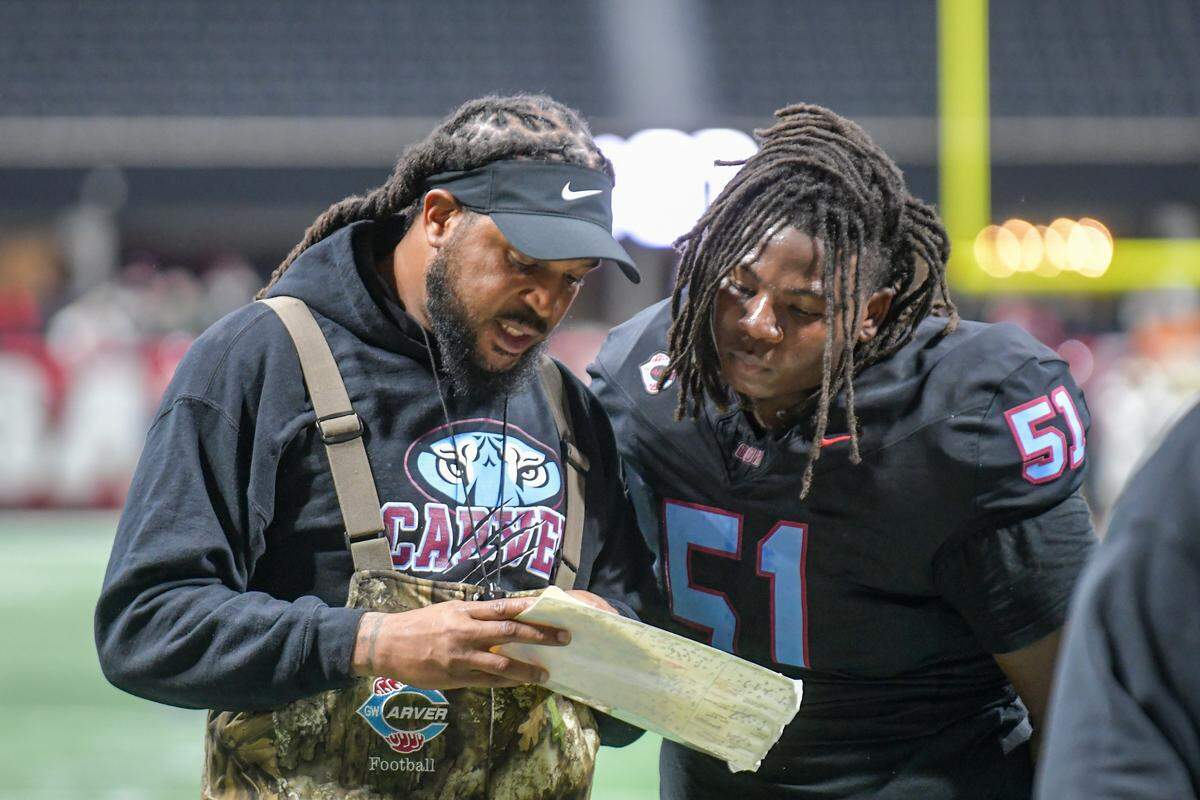 Carver head football coach Jarvis Jones talks with senior defensive tackle Nic’quayvion Simmons during the Georgia High School Association Class 2A football state championship game Dec. 16, 2025, at Mercedes-Benz Stadium in Atlanta.