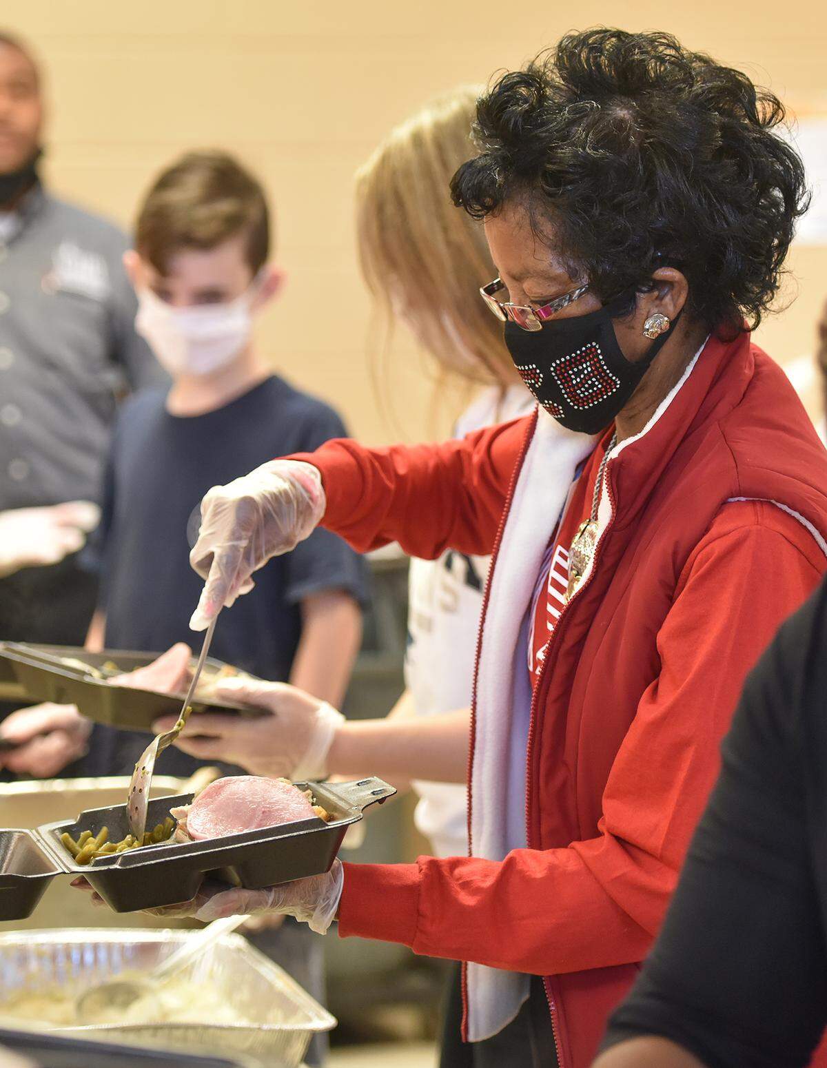 Evelyn Dorsey, a volunteer for 40 years at Valley Rescue Mission in Columbus, Georgia for their Thanksgiving service, helps prepare serving trays on Thursday, November 26, 2020.