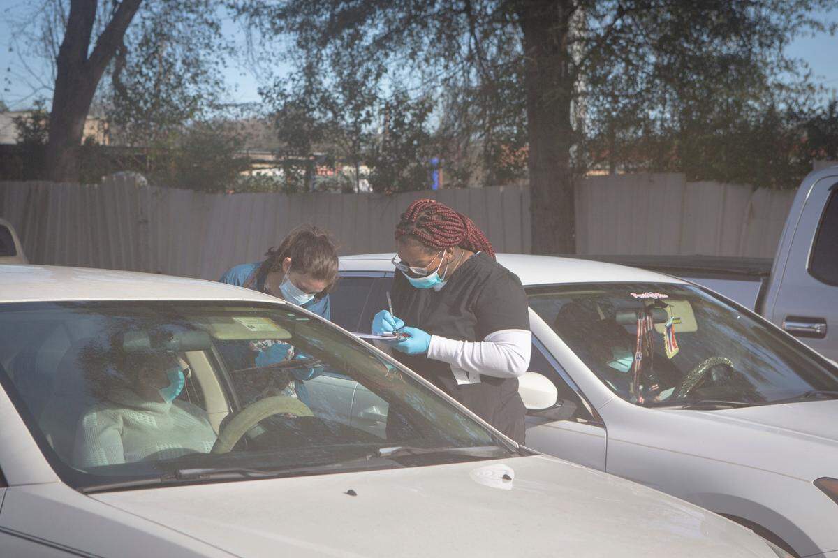 Physicians Adrian King and Kynidee Brooks register people for the drive-thru COVID-19 testing site at the Greater Ward Chapel AME Church in Columbus, Ga. on Jan. 10, 2022.