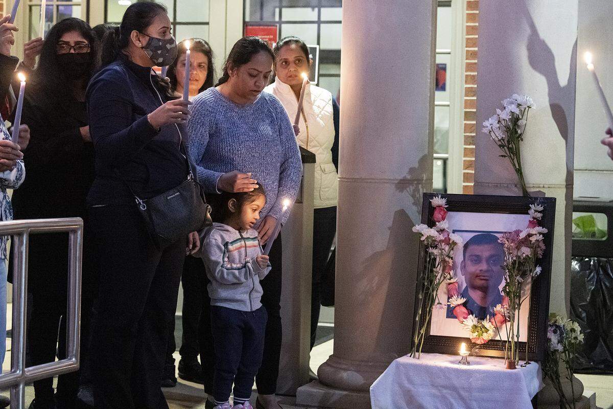 Family and friends of Amit Kumar Patel gather for a candlelight vigil in his memory Monday evening outside of a Synovus branch at 4505 Buena Vista Road in Columbus, Georgia, where he was fatally shot. 12/13/2021