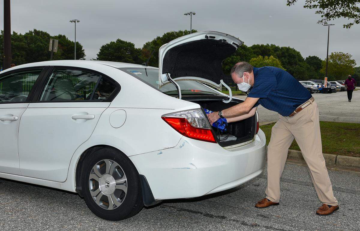 Muscogee County School District superintendent David Lewis helps load backpacks full of school supplies into cars at the 7th Annual Citywide Back to School Jam at the Columbus Civic Center by Amerigroup and other community partners. Attendees were required to stay in their vehicles at all times with their windows up, Saturday, August 1, 2020.