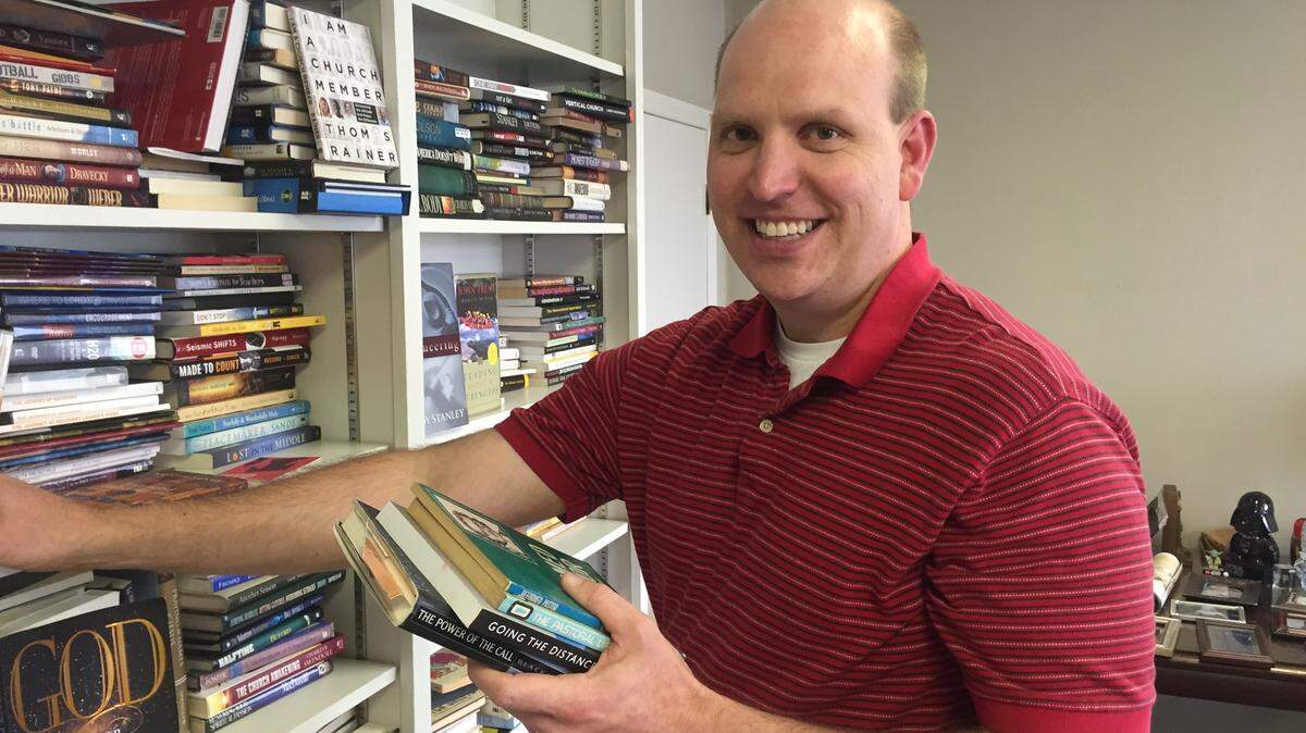 Special to the Ledger-EnquirerThe Rev. Cade Farris of the First Baptist Church on the Square in LaGrange, Ga., shelves books in his office.