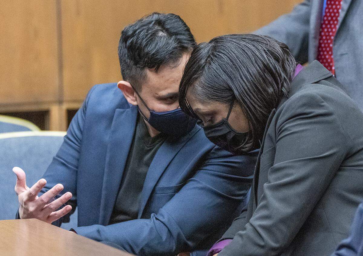 Albert and Ashley Debelbot speak to each other at the defendants’ table as their attorneys wait for Judge Arthur Smith’s decision to dismiss the charges against them, Tuesday, April 13, 2021