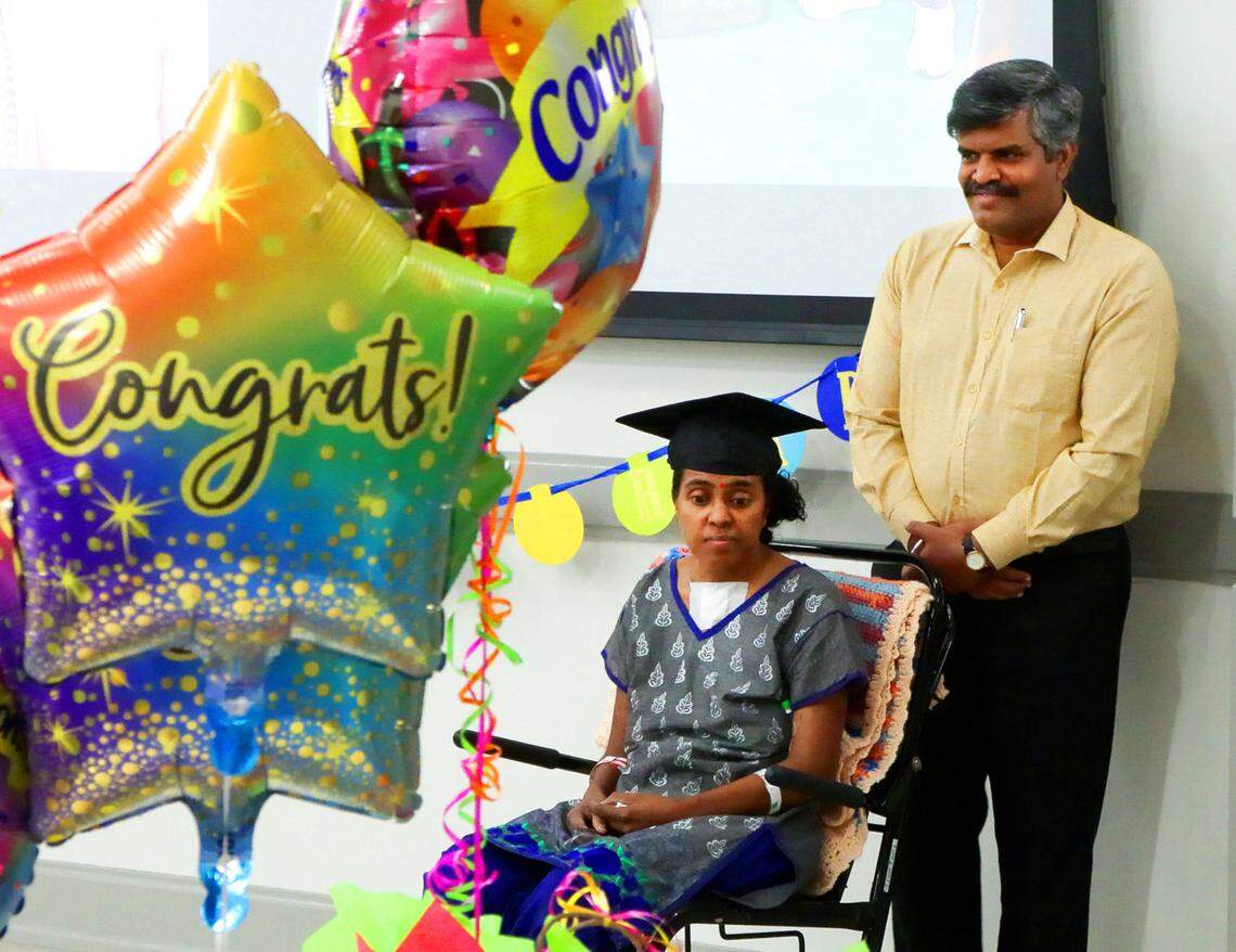 V. Balakumar stands next to his wife Mirna Balakumar during a graduation party Piedmont Columbus Regional hosted on June 25, 2025, for Mirna, a patient at Piedmont who has been recovering since she was struck by a car in April, three days after earning a master’s degree.
