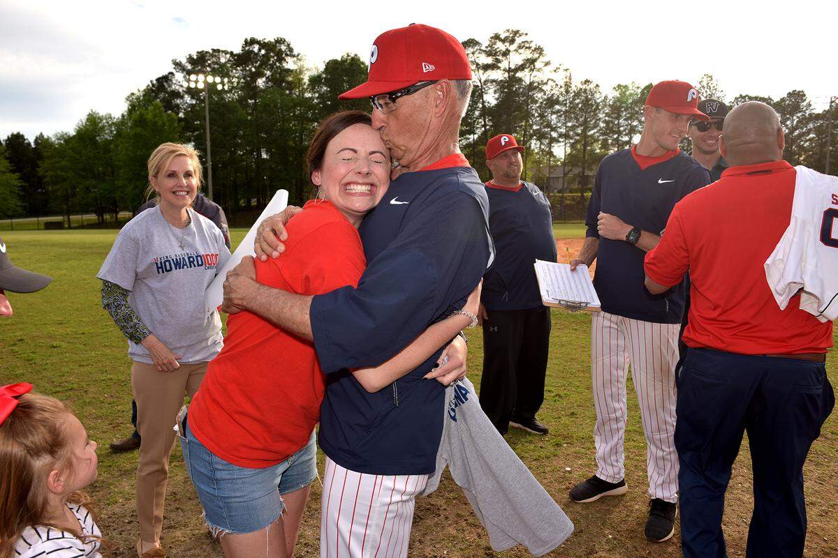 St. Anne-Pacelli head baseball coach Bobby Howard kisses his daughter Lindsey Howard Grubbs as she gives him a congratulatory hug after the Vikings defeated Webster County 8-3 Monday afternoon, giving Howard his 1000th career win.