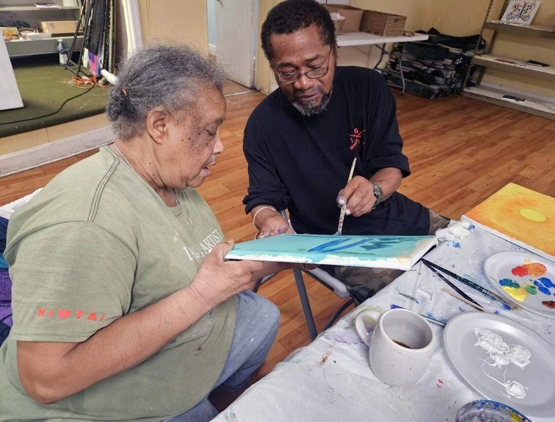 Edwin Grier, right, assists Janie Cunningham in the Home Is Where the Art Is program in Columbus.