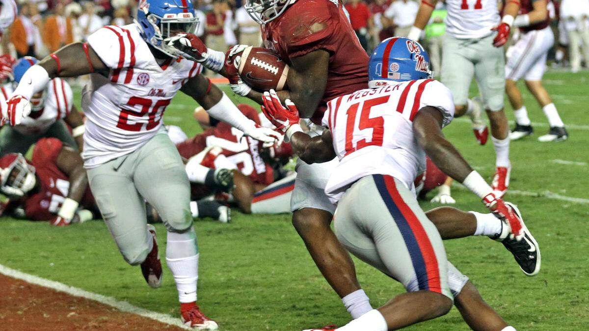 Alabama running back Derrick Henry, center, carries the ball in for a touchdown between Mississippi linebacker Christian Russell, left, and defensive back Kendarius Webster, right, during the second half of an NCAA college football game, Saturday, Sept. 19, 2015, in Tuscaloosa, Ala. (AP Photo/Butch Dill)