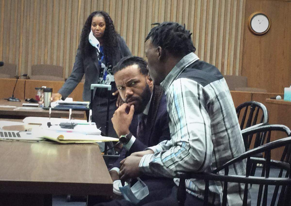 Left to right, Acting District Attorney Sheneka Terry stands as defense attorney William Kendrick confers with Demetrius Johnson.