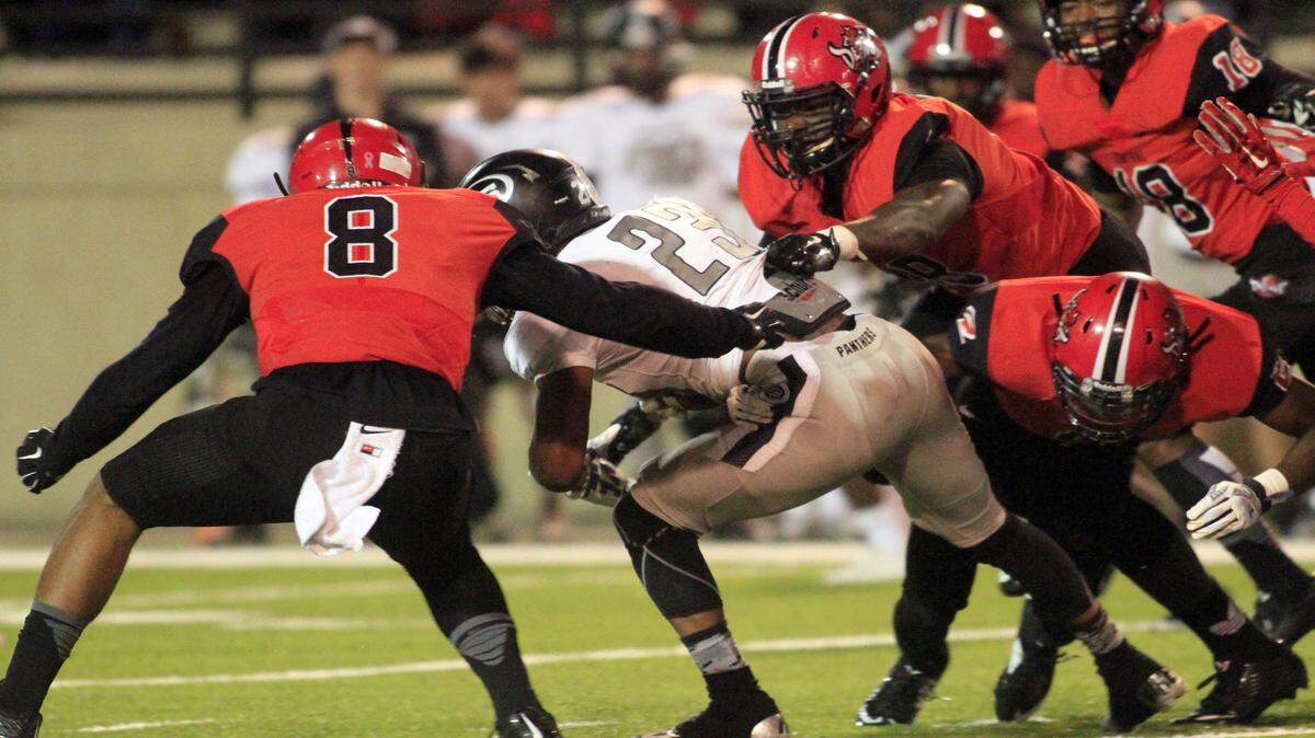 ROBIN TRIMARCHI rtrimarchi@ledger-enquirer.com 
 The Central High defense wraps up Smiths Station running back K.J Johnson in the first half Friday at Garrett-Harrison Stadium. 10.02.15