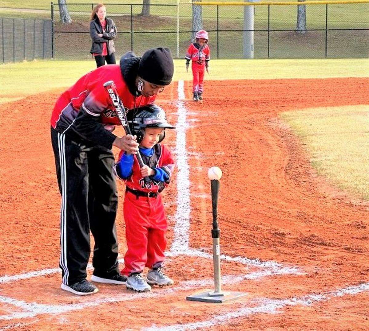 Sally Little League board member Salathiel Long coaches a T-ball player.