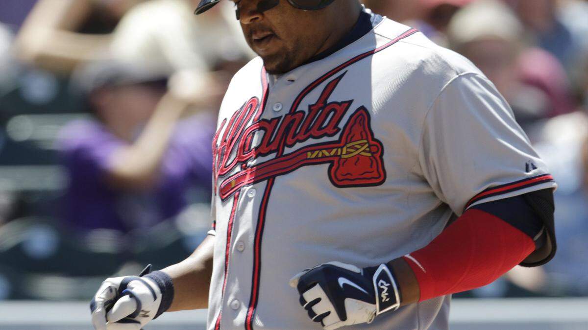 Atlanta Braves' Juan Uribe crosses the plate after hitting a home run against the Colorado Rockies in the second inning of a baseball game in Denver, Saturday, July 11, 2015. (AP Photo/Joe Mahoney)