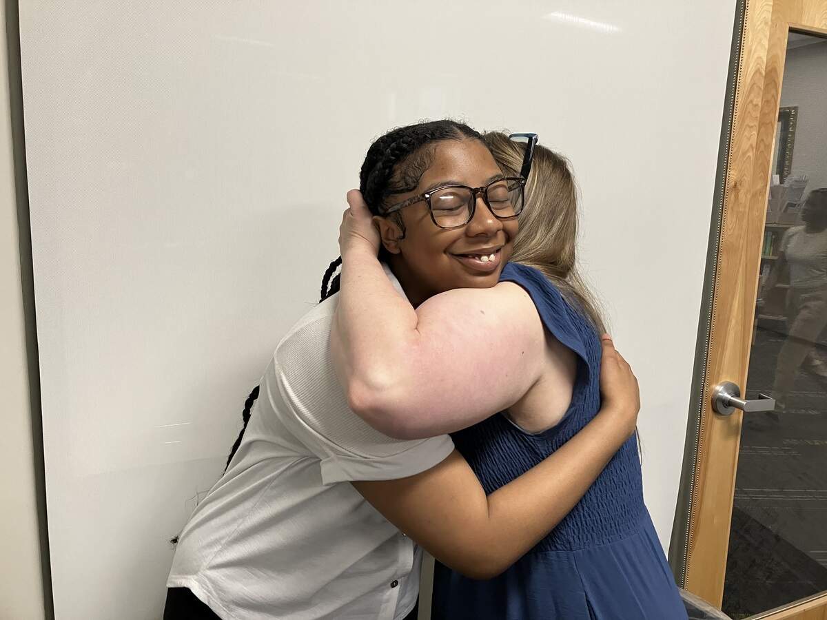 Spencer High School senior Emaureia Mathis of Columbus, left, and Bethany Collins, chairwoman of the Career, Technical and Agricultural Education department at Spencer, embrace after their May 2026 interview with the Ledger-Enquirer at the school, where they shared Emaureia’s journey of overcoming her speech impediment to win the speaking skills competition during the 2026 Georgia Health Occupations Students of America State Leadership Conference at the Atlanta Marriott Marquis.