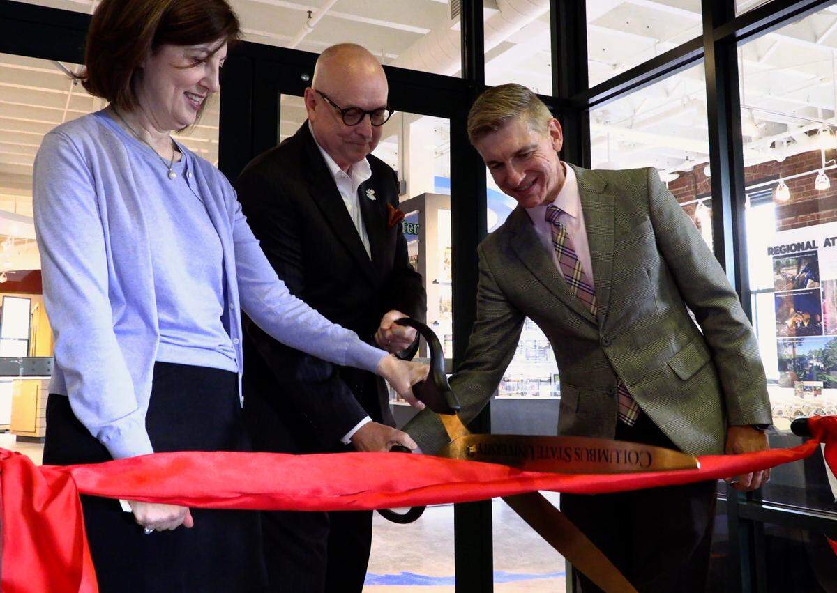 From left, Marianne Richter, director of the Columbus Museum, Peter Bowden, president and CEO of VisitColumbusGA, and Kevin Langston, Deputy Commissioner of Tourism at the Georgia Department of Economic Development, cut the ribbon during a 2018 re-dedication of VisitColumbusGA’s remodeled visitors center at 900 Front Ave. in Columbus.