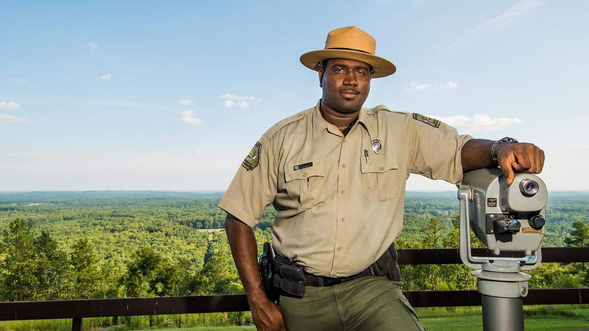 Desmond Timmons, manager of F.D. Roosevelt State Park in nearby Pine Mountain, Ga., in Harris County, poses outside the park's visitor center and administrative office, with a view of Pine Mountain Valley in the distance. Timmons, a south Georgia native who played basketball at Columbus State University, joined the park in January 2012, with it recently receiving an award for best-programming among Georgia state parks.