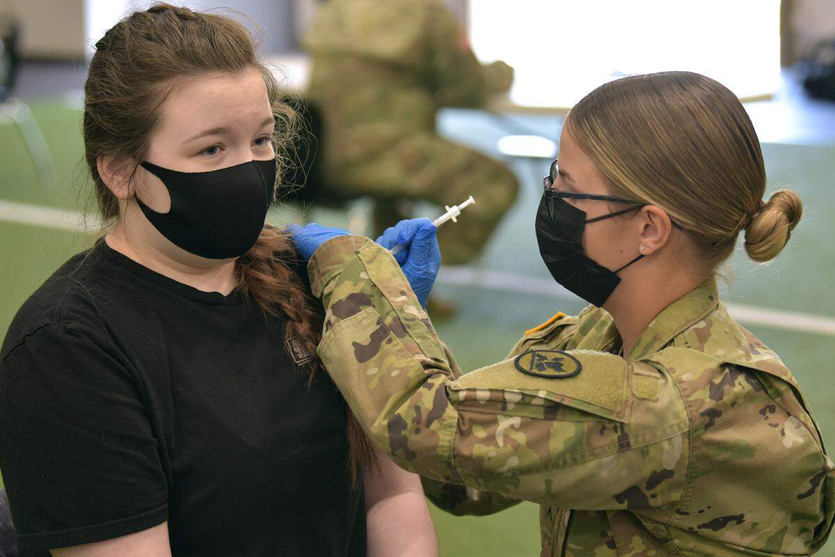 Central High School student Katie Suchman receives a Pfizer vaccine shot from National Guard Pvt. Heather Pupp at Central High School Thursday morning.