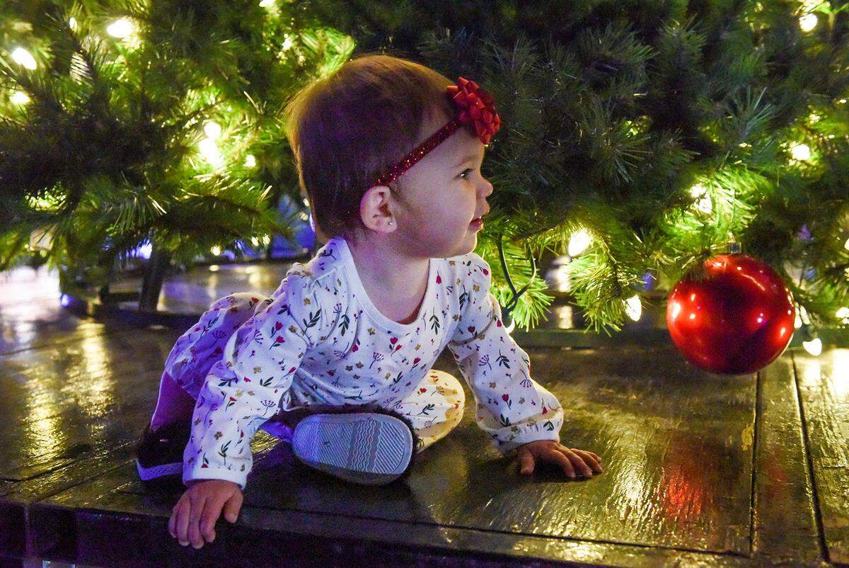 One-year-old Ava Besquez plays under the Christmas tree at Columbus State University’s WinterFest celebration, Tuesday, November 19, 2019 on main campus.