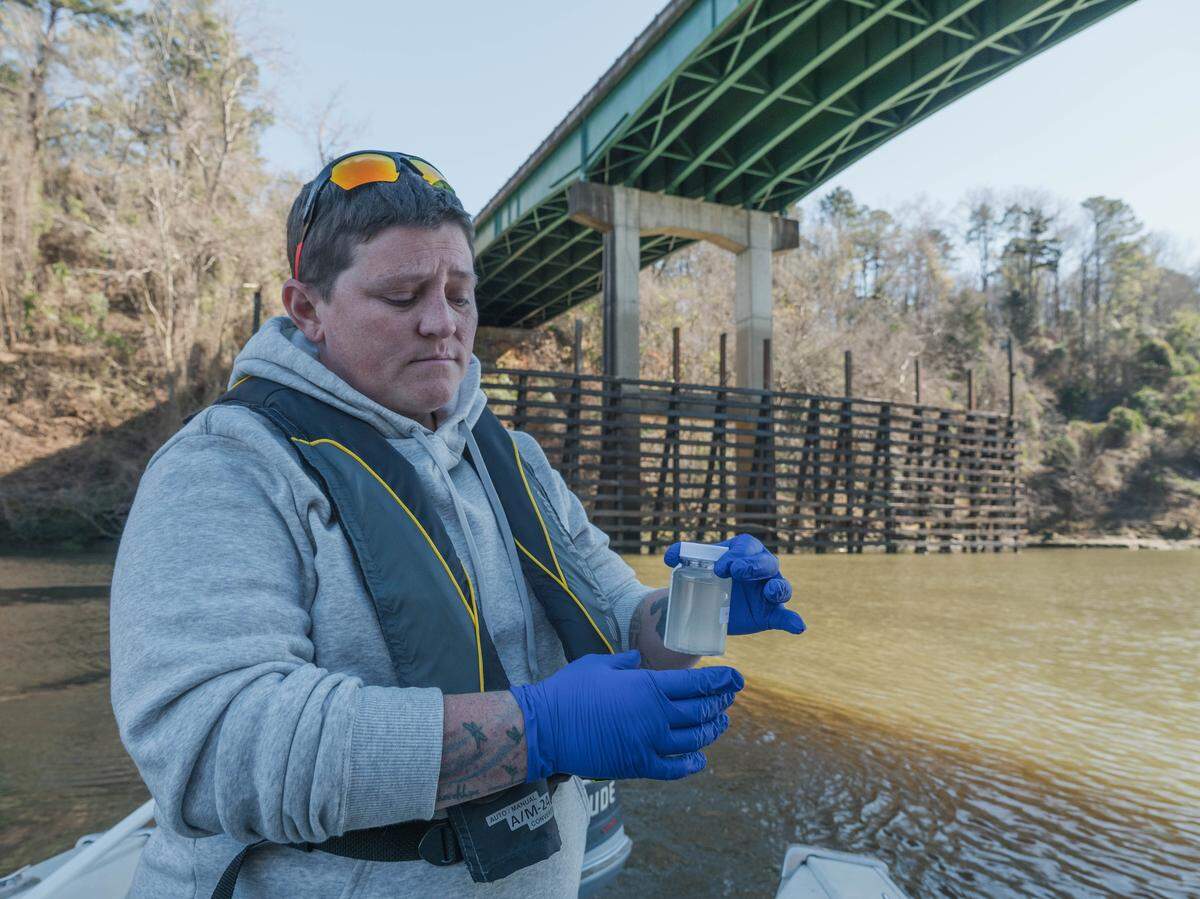 Ashley Desensi collects a water sample for the Chattahoochee Riverkeeper water quality testing at Fort Gaines water treatment outfall.