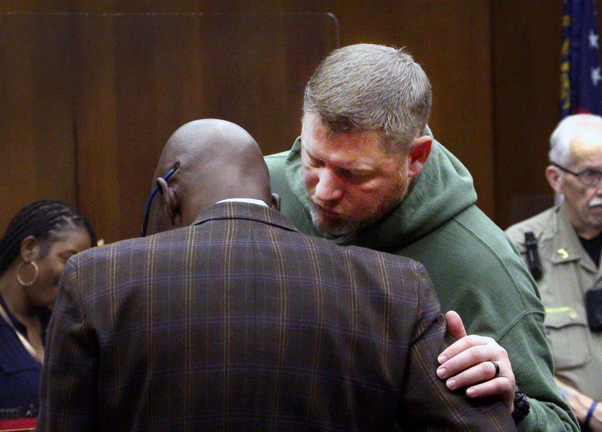 Michael O’Keefe, an investigator with the Muscogee County Sheriff’s Office, facing camera, speaks with District Attorney Stacey Jackson Friday morning before a hearing for local attorney Allen Jones, 51.
