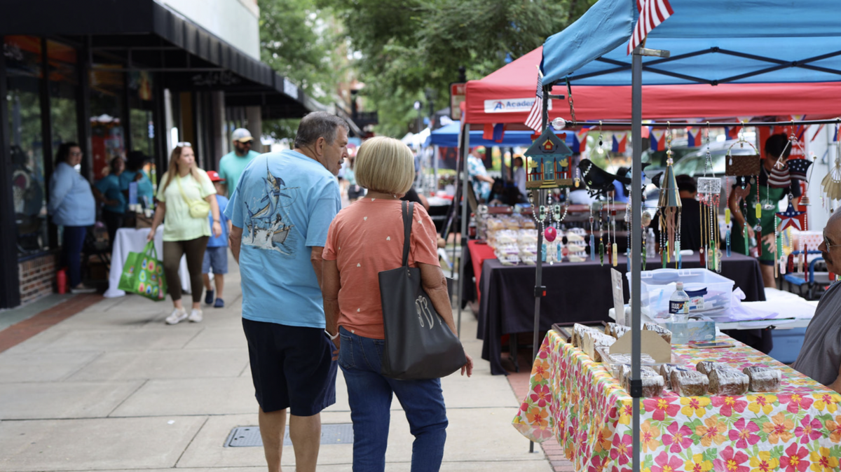 Uptown Market Days on Broadway in 2022. Shoppers look at product options from local artisans.
