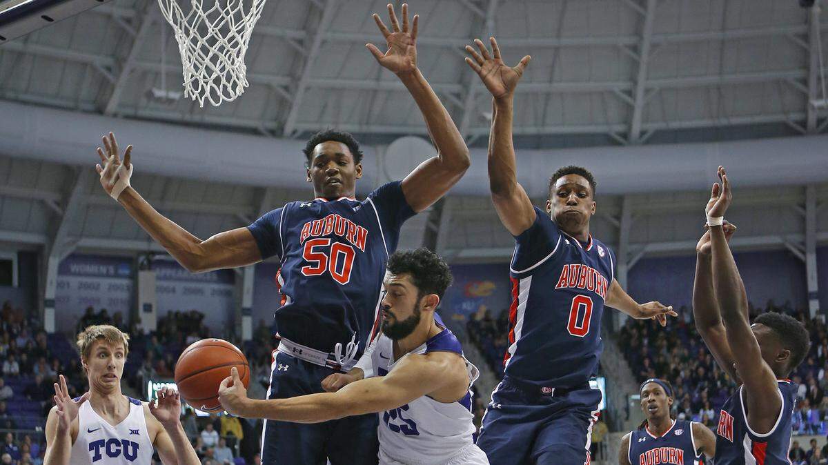TCU guard Alex Robinson (25) passes to forward Vladimir Brodziansky (10) under the basket and past Auburn defenders Austin Wiley (50) and Horace Spancer (9) during the second half of an NCAA college basketball game in Fort Worth, Texas, Saturday, Jan. 28, 2017