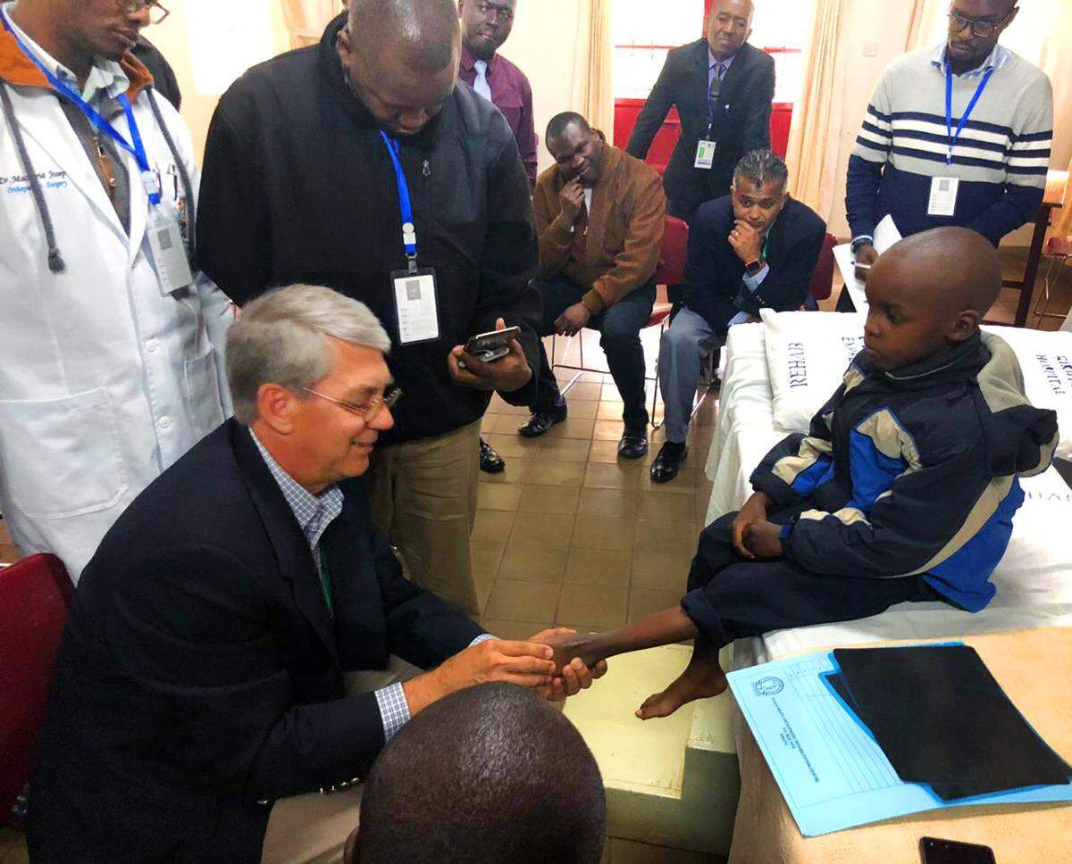 Dr. Leland McCluskey, an orthopedic surgeon at St. Francis-Emory Healthcare in Columbus, examines a patient being treated in the Steps2Walk program in Kenya.