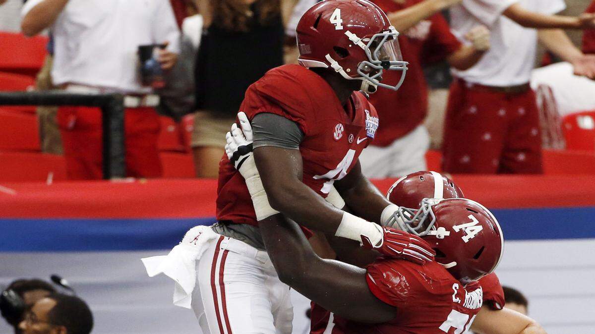 JOHN BAZEMORE/Associated Press 
 Alabama running back T.J. Yeldon (4) celebrates with offensive linesman Cam Robinson (74) after scoring a touchdown against West Virginia in the first half Aug. 30, 2014, in Atlanta. Left tackle Robinson is joined by right guard Alphonse Taylor and left guard Ross Pierschbacher as returning starters on the Alabama offensive line.