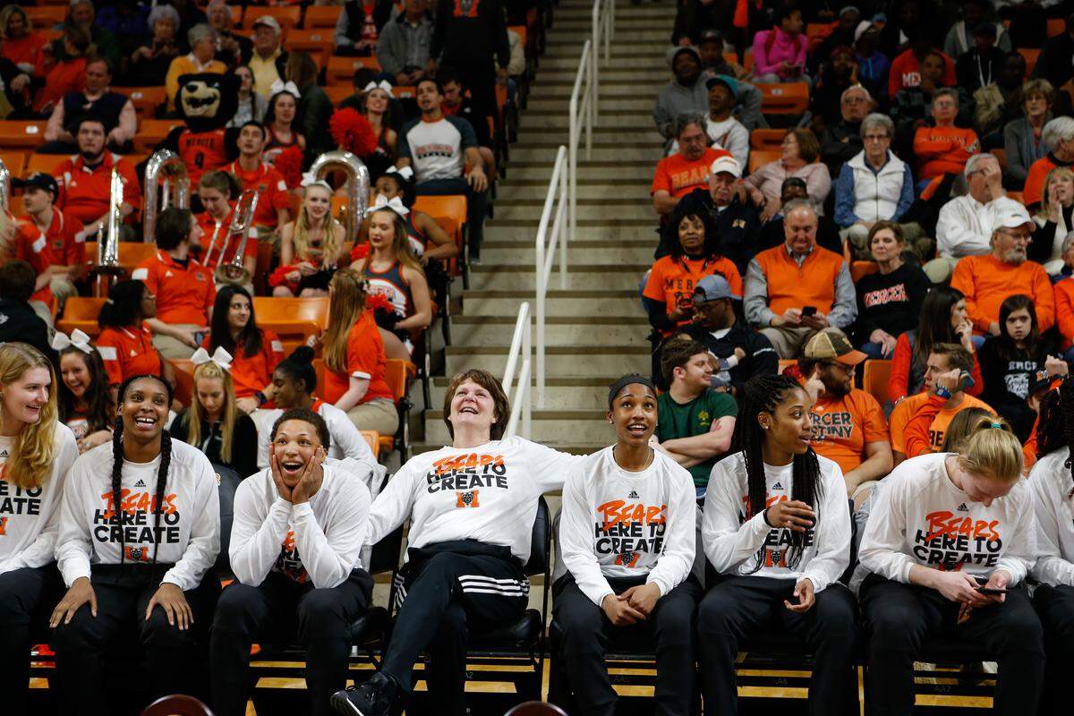 Mercer senior guard Kahlia Lawrence (third from from left) takes in the news of Mercer's NCAA Tournament seeding while head coach Susie Gardner (middle) and Lawrence's teammates take in the moment