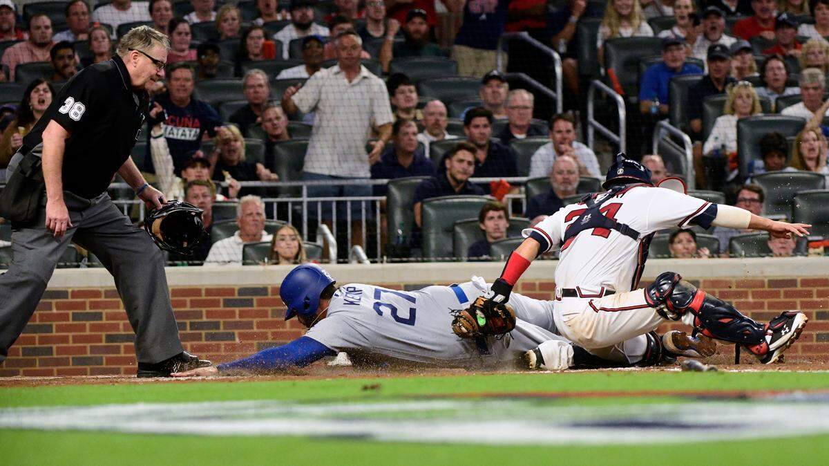 Atlanta Braves catcher Kurt Suzuki (24) tags out Los Angeles Dodgers’ Matt Kemp (27) at the plate during the sixth inning in Game 3 of the National League Division Series on Oct. 7 in Atlanta.