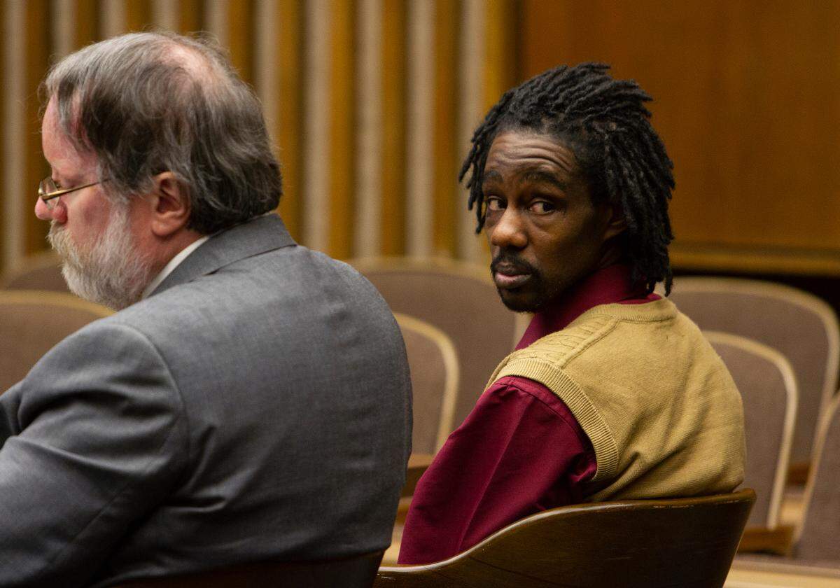 Defendant Eddie Clayton sits with Mark Shelnutt, one of his lawyers, while looking back towards the back of the courtroom on Tuesday, April 16, 2019, in Columbus, Ga. Clayton is charged with murder among other charges.