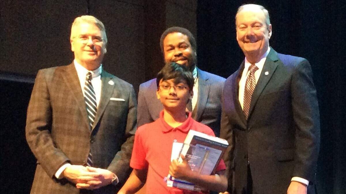 Reese Road Leadership Academy fifth-grader Ryan Tadiparthi, 10, is congratulated by, from left, Columbus Mayor Skip Henderson, Muscogee Association of Educators president Darryl Carter and Muscogee County School District superintendent David Lewis after winning the 2019 MCSD Spelling Bee in the Rainey-McCullers School of the Arts auditorium Wednesday, February 6.