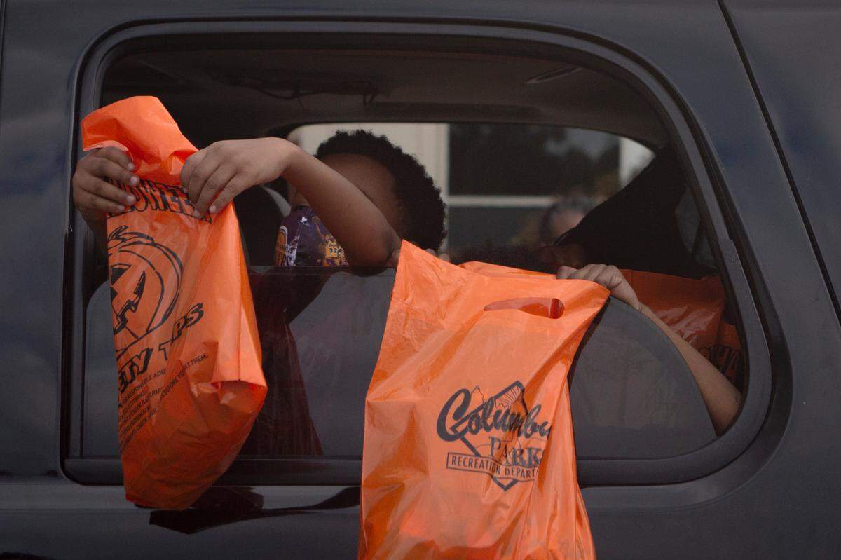 Wearing masks, young children trick-or-treat out of their cars during the Spooktacular Trunk or Treat event on Sunday, Oct. 25, 2020 at the Civic Center in Columbus.
