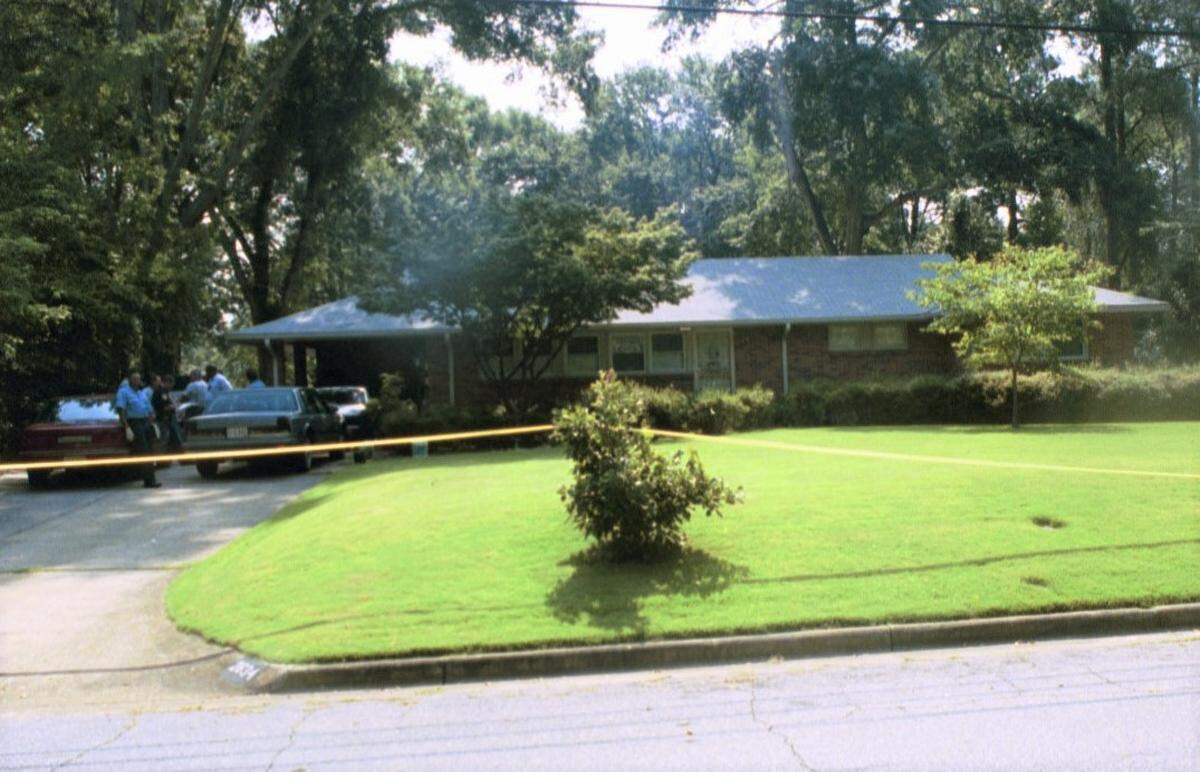 Crime-scene tape marks the Habersham Avenue home where Albert Woolfolk was found slain around 10:15 a.m. on July 18, 2003.