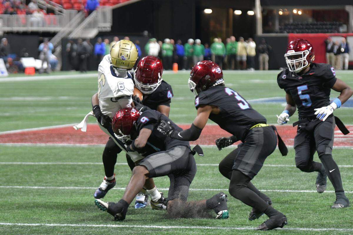 Carver defenders converge for a tackle against Hapeville Charter during the Georgia High School Association Class 2A football state championship game Dec. 16, 2025, at Mercedes-Benz Stadium in Atlanta.