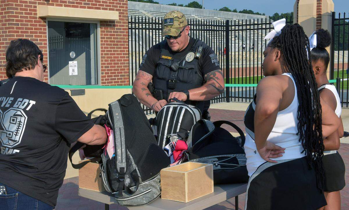 An officer with the Muscogee County School District’s police department inspects a bag at Odis Spencer Stadium in Columbus, Georgia prior to the Aug. 24, 2023 varsity football game between Kendrick High School and Shaw High School. 08/24/2023