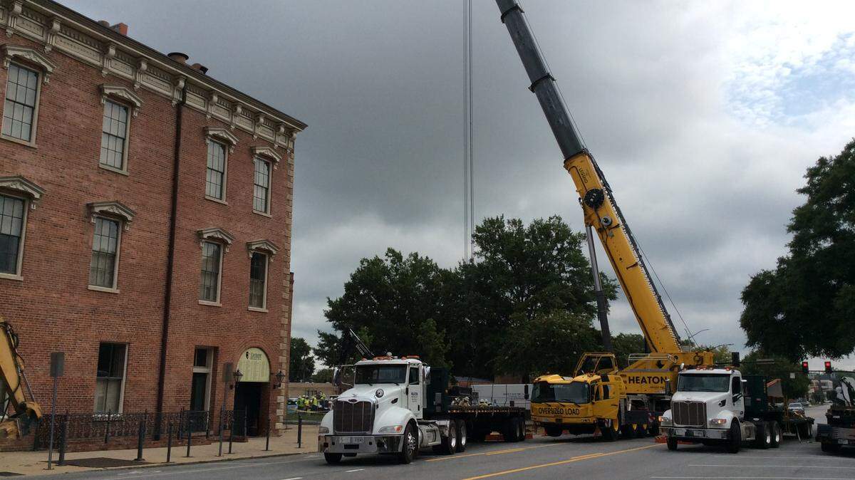A large crane works Thursday morning to put the Georgia Power high-reliability network in place along 10th Street next to the Springer Opera House.
