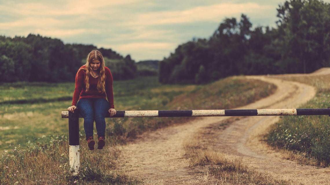 https://www.pexels.com/photo/woman-sitting-on-metal-gate-pass-beside-mud-road-277013/