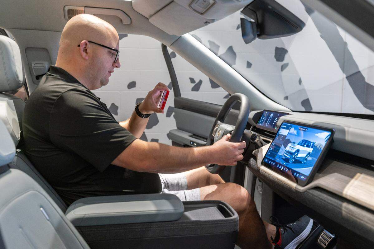 Jose Castillo sits in the new Rivian R2 prototype and records his experience at the Ponce City Market in Atlanta on April 27, 2024. (Steve Schaefer / AJC)