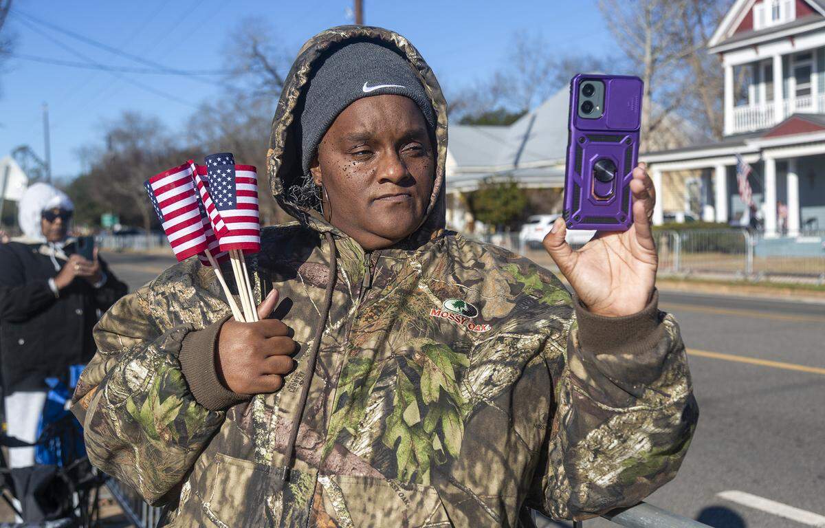 A spectator watches as law enforcement leaves downtown Plains, GA, on their way to Americus to begin former President Jimmy Carter’s motorcade