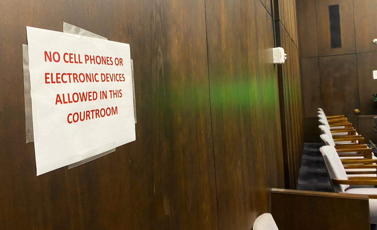 A sign in Judge Gil McBride’s Government Center courtroom warns visitors that no cell phones are allowed in the audience during a gang murder trial.