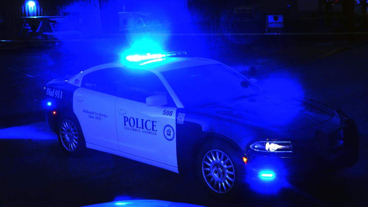 A Columbus Police Department patrol car blocks an intersection in Columbus, Georgia as investigators process a crime scene.