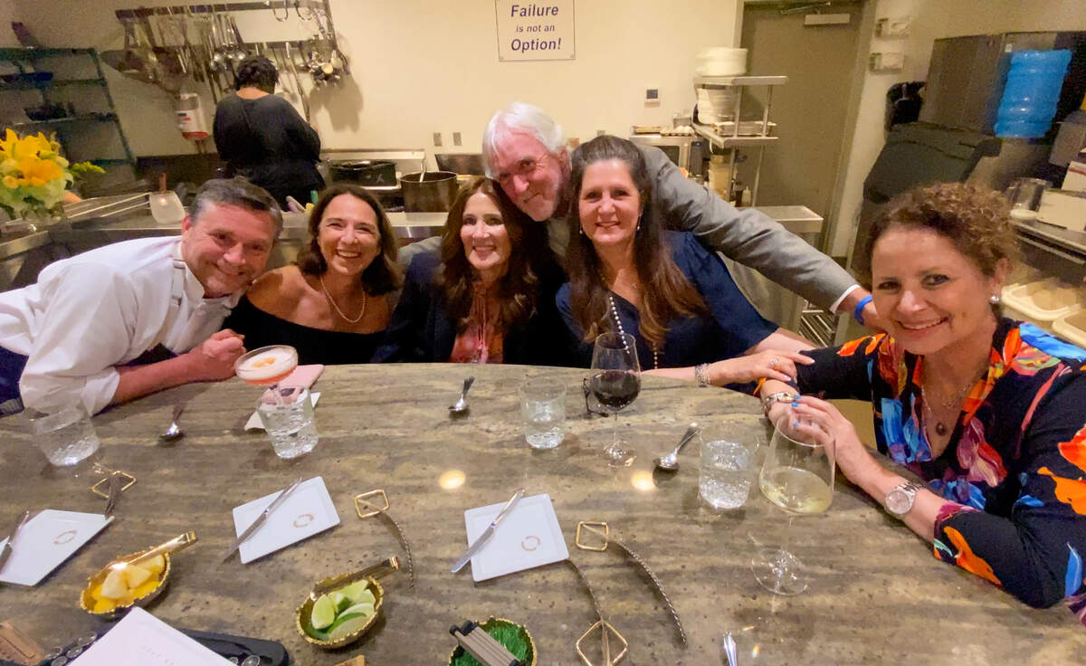 Epic Restaurant co-owner and head chef Jamie Keating, far left, and “Theo of Golden” author Allen Levi pose for a photo with the “THEO-logians” during their dinner at the Epic chef’s table.