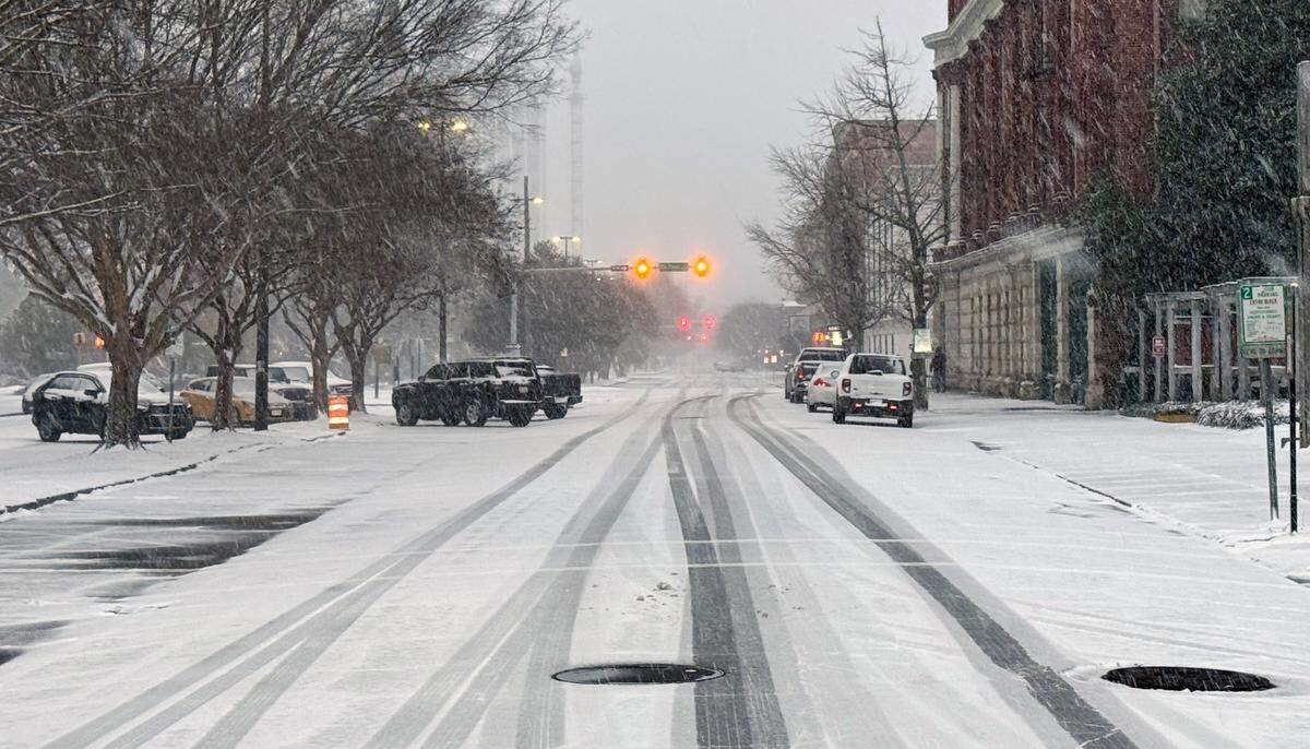 Snow covering First Avenue in downtown Columbus, Georgia made driving challenging.