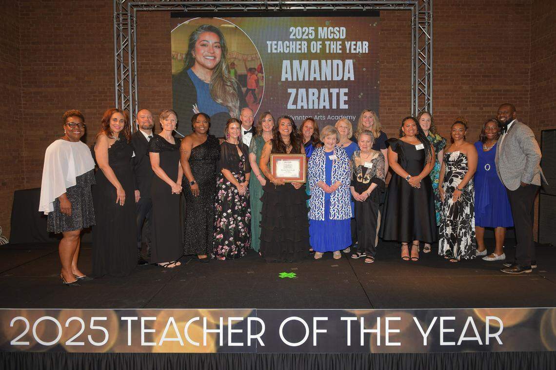 Amanda Zarate, a theater teacher at Wynnton Arts Academy, poses with former Muscogee County School District Teacher of the Year award winners, MCSD officials and supporters after she was announced as the 2025 winner during the Muscogee Educational Excellence Foundation gala May 1 in the Columbus Convention & Trade Center.