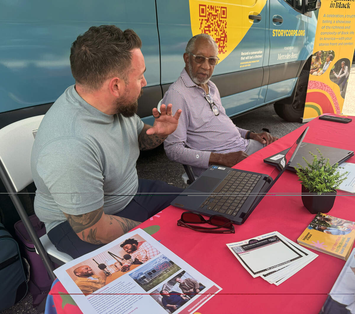 Justin Cummins, associate director of interview collection for StoryCorps, left, speaks with Columbus resident Bob Wright during the June 2026 StoryCorps stop in Columbus at the Liberty Theatre.