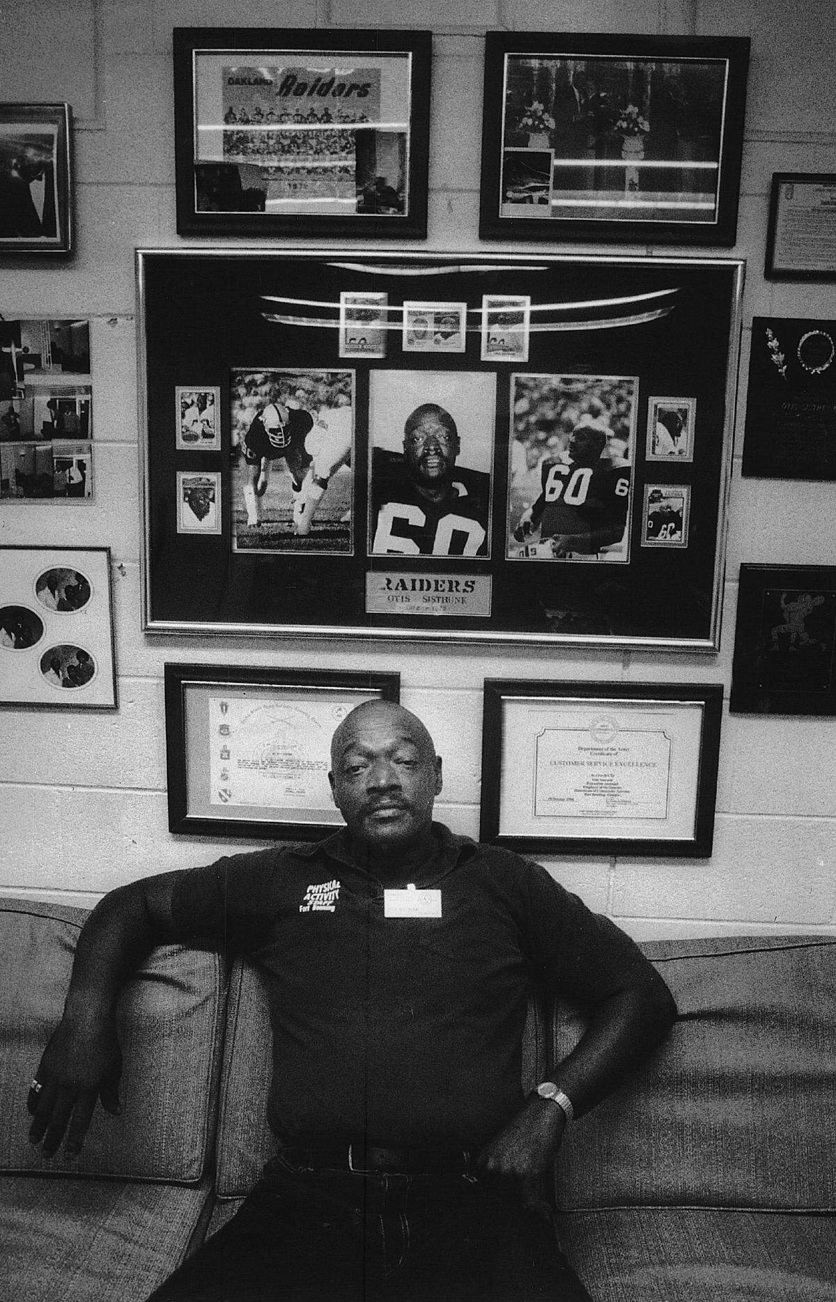 Otis Sistrunk sits in front of memorabilia from his playing career.